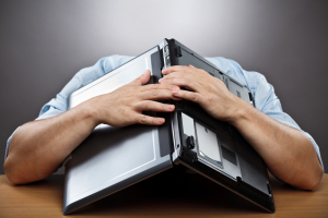 exhausted-businessman-covering-his-head-with-his-laptop_pop_15451
